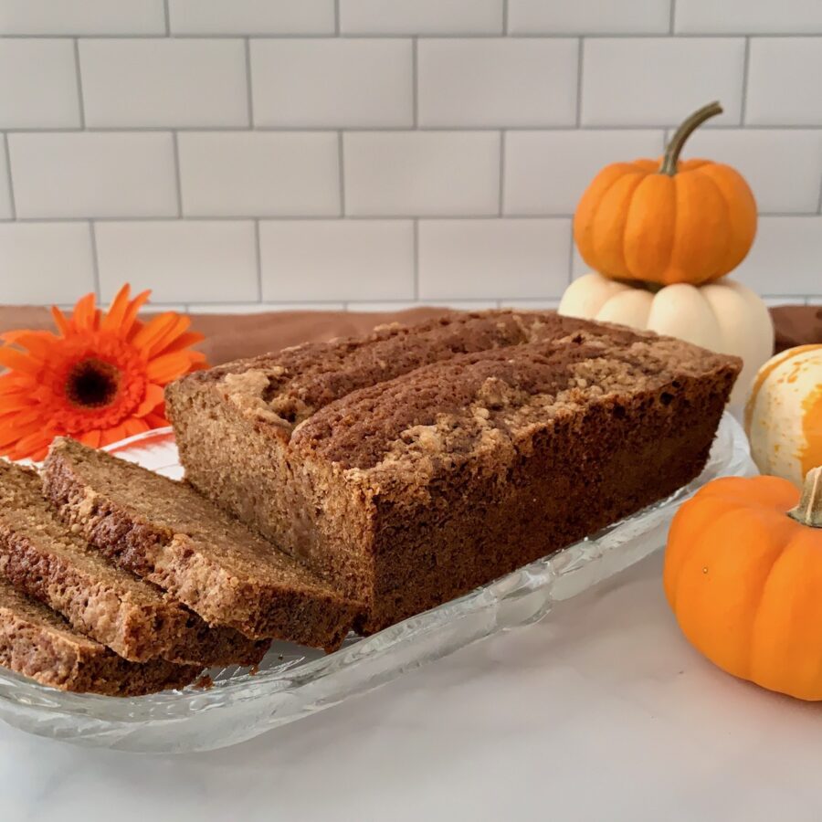 Sourdough Spice Cake sliced on plate with pumpkins