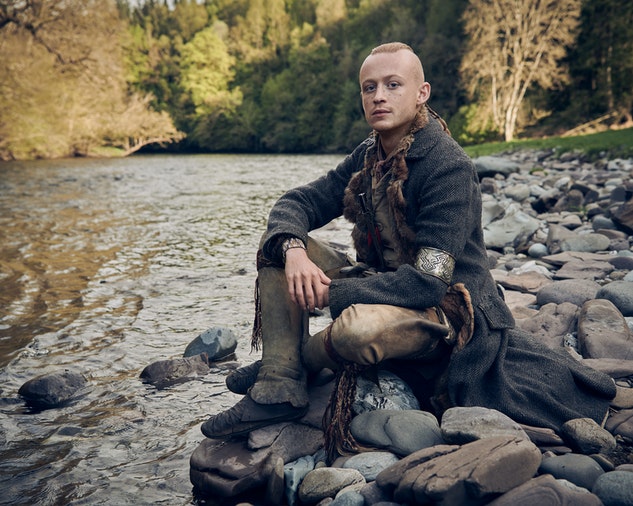 Ian Murray seated on rocks beside a creek in a season 6 promotional still