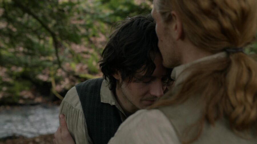 Jamie kissing Fergus on the forehead. 