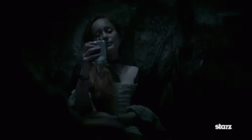 Geilis Duncan drinking from a silver flask in the thieves’ hole from season 1