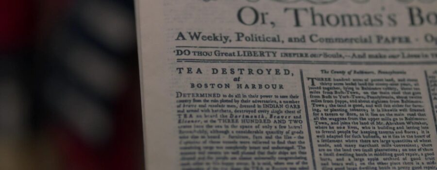 Closeup of an old newspaper story with the headline about the Boston Tea Party.